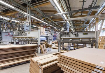 Presses pour les ébauches de portes, toutes les portes extérieures et spéciales sont produites dans la chaîne de production manuelle. | © RIWAG Türen AG